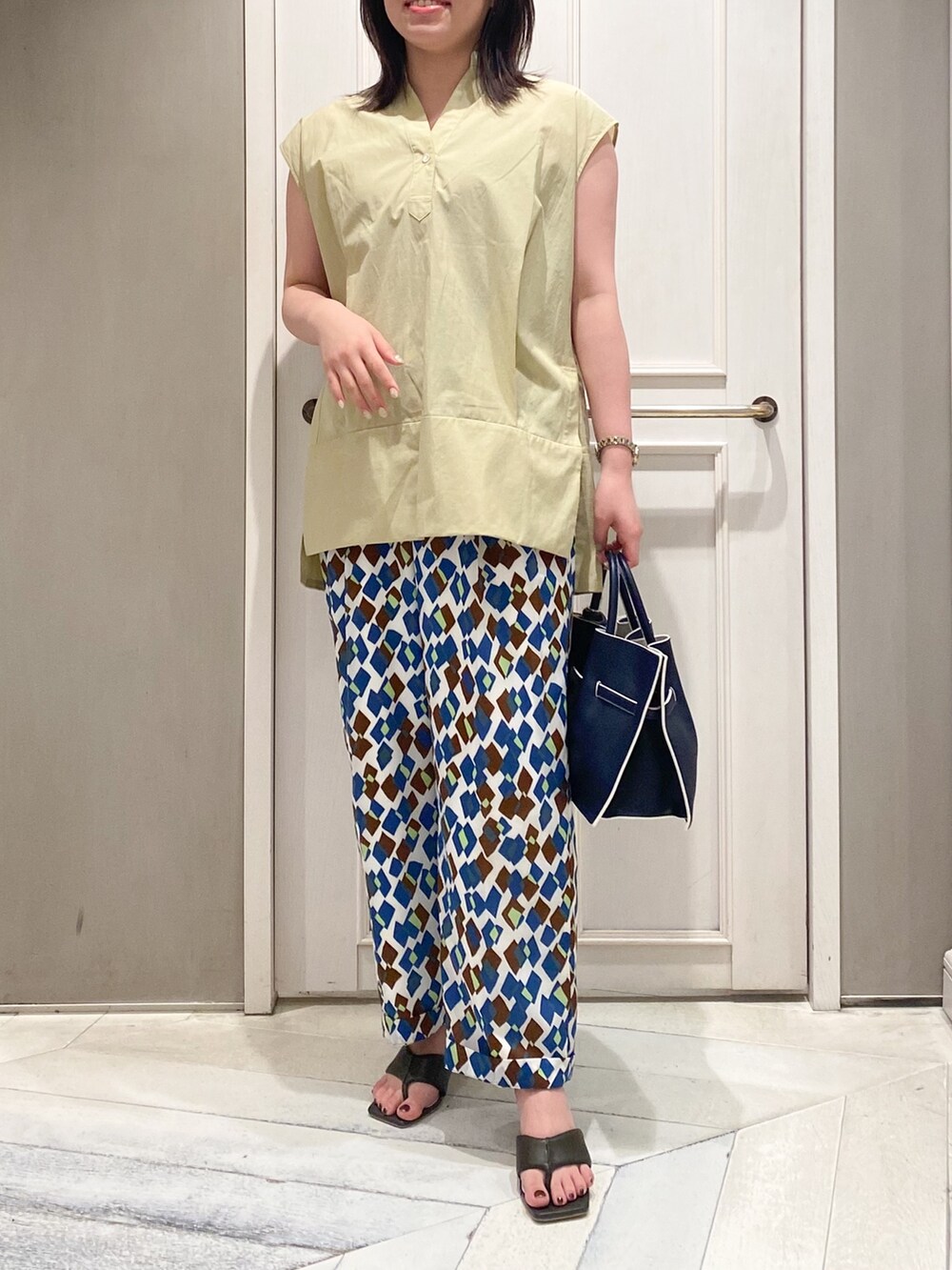 イエロー系のシャツ/ブラウス、その他のその他パンツ、ブルー系のハンドバッグを着用したレディースの春コーディネートの3枚目の写真