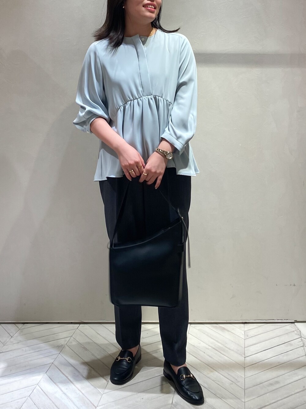 ブルー系のシャツ/ブラウス、グレー系のスラックスを着用したレディースの秋コーディネートの6枚目の写真