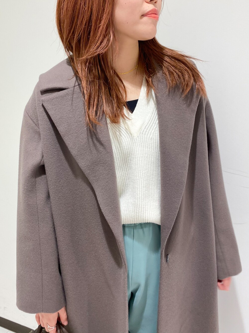 グリーン系のその他パンツ、ホワイト系のニット/セーター、ブラウン系のチェスターコートを着用したレディースの秋コーディネートの3枚目の写真