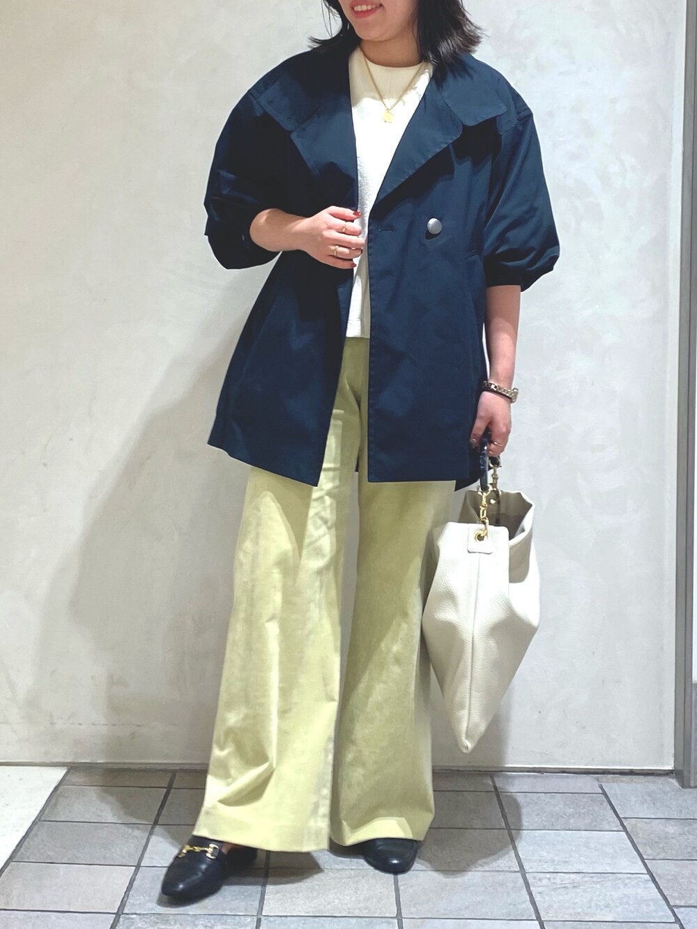 ホワイト系のTシャツ/カットソー、ブルー系のトレンチコート、グリーン系のその他パンツを着用したレディースの秋コーディネートの2枚目の写真