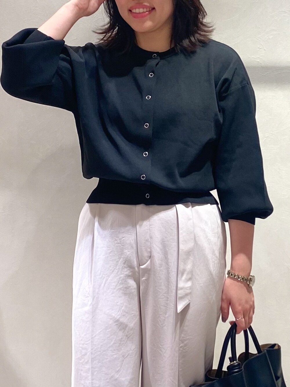 ブラック系のカーディガン/ボレロ、ピンク系のスラックス、ブラック系のトートバッグを着用したレディースの秋コーディネートの7枚目の写真