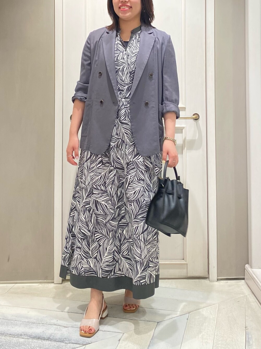 グレー系のワンピース、グレー系のテーラードジャケット、グリーン系のトートバッグを着用したレディースの夏コーディネートの4枚目の写真