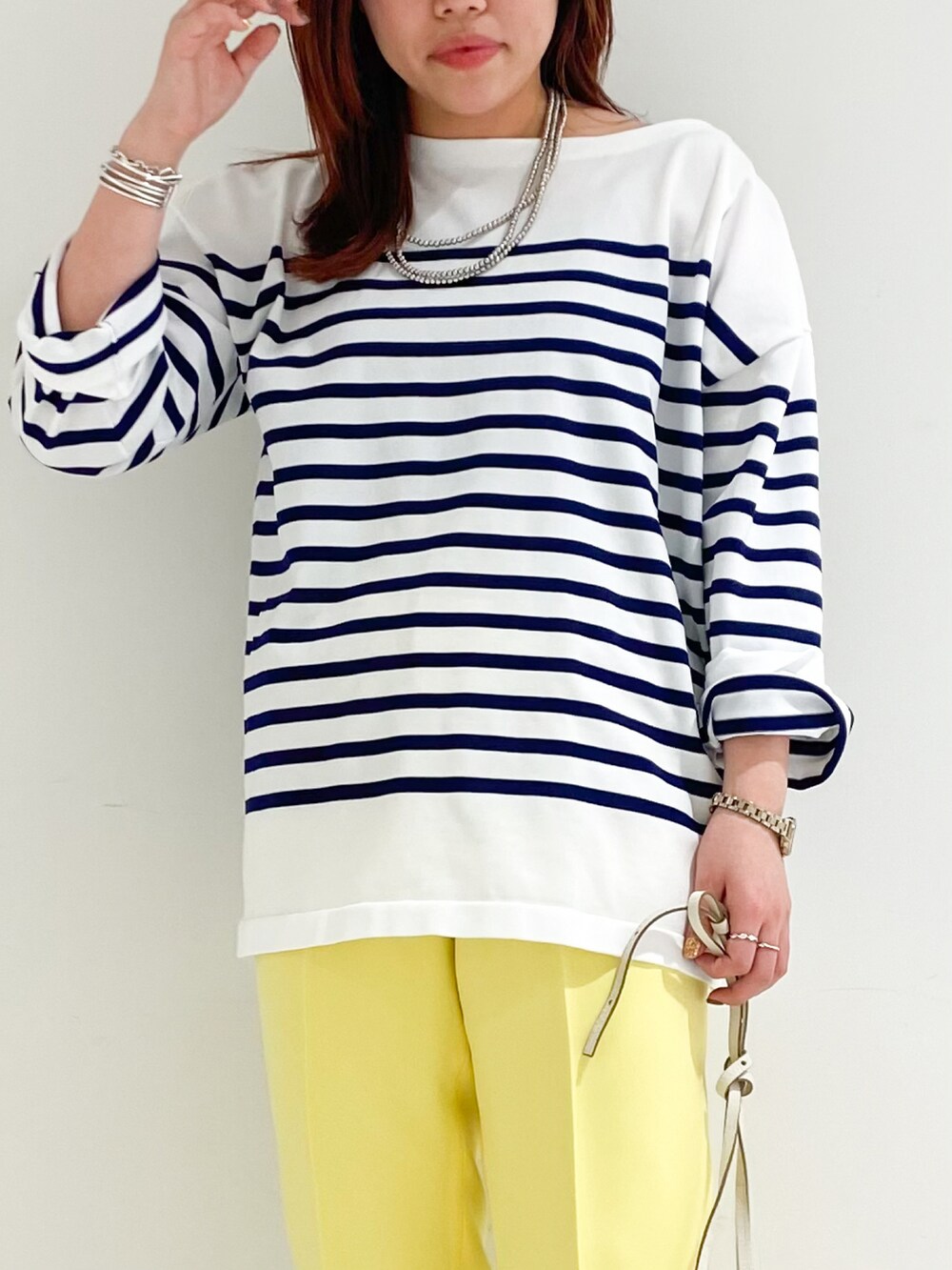 ブルー系のニット/セーター、ホワイト系のショルダーバッグ、ブラック系のパンプスを着用したレディースの冬コーディネートの3枚目の写真