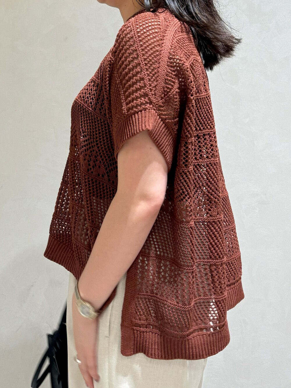 ブラウン系のニット/セーター、ホワイト系のトートバッグを着用したレディースの夏コーディネートの8枚目の写真