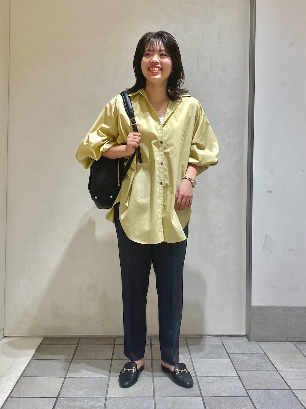 ベージュ系のシャツ/ブラウス、グレー系のスラックス、ブラック系のバックパック/リュックを着用したレディースの秋コーディネートの5枚目の写真