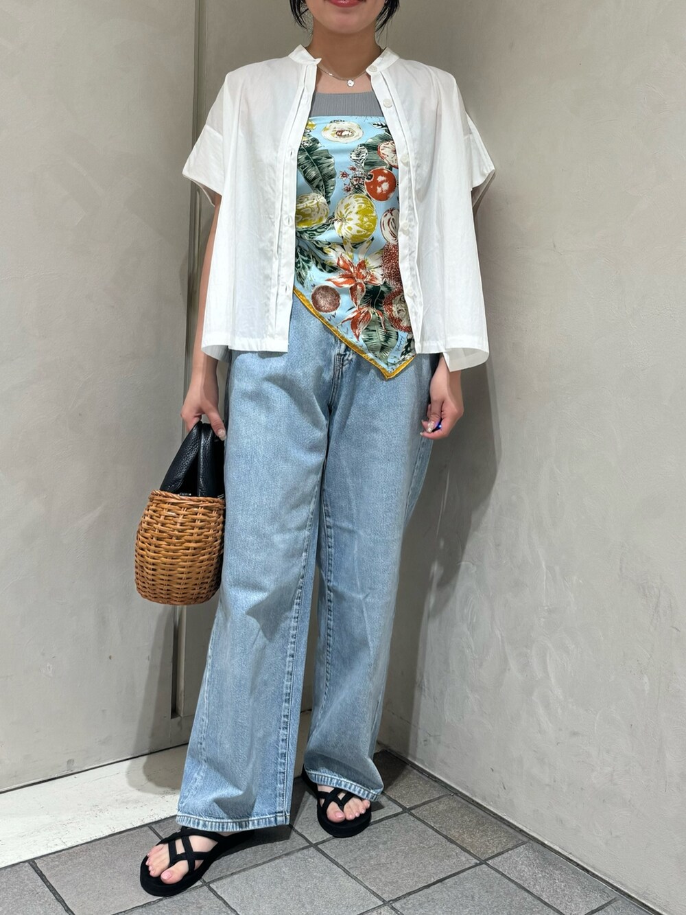 ブラック系のトートバッグ、ブルー系のデニムパンツ、ホワイト系のシャツ/ブラウスを着用したレディースの夏コーディネートの2枚目の写真