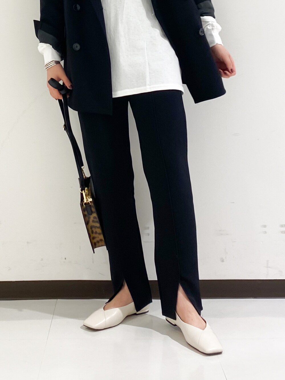 ブラック系のTシャツ/カットソー、ブラウン系のその他パンツ、ホワイト系のパンプスを着用したレディースの秋コーディネートの3枚目の写真