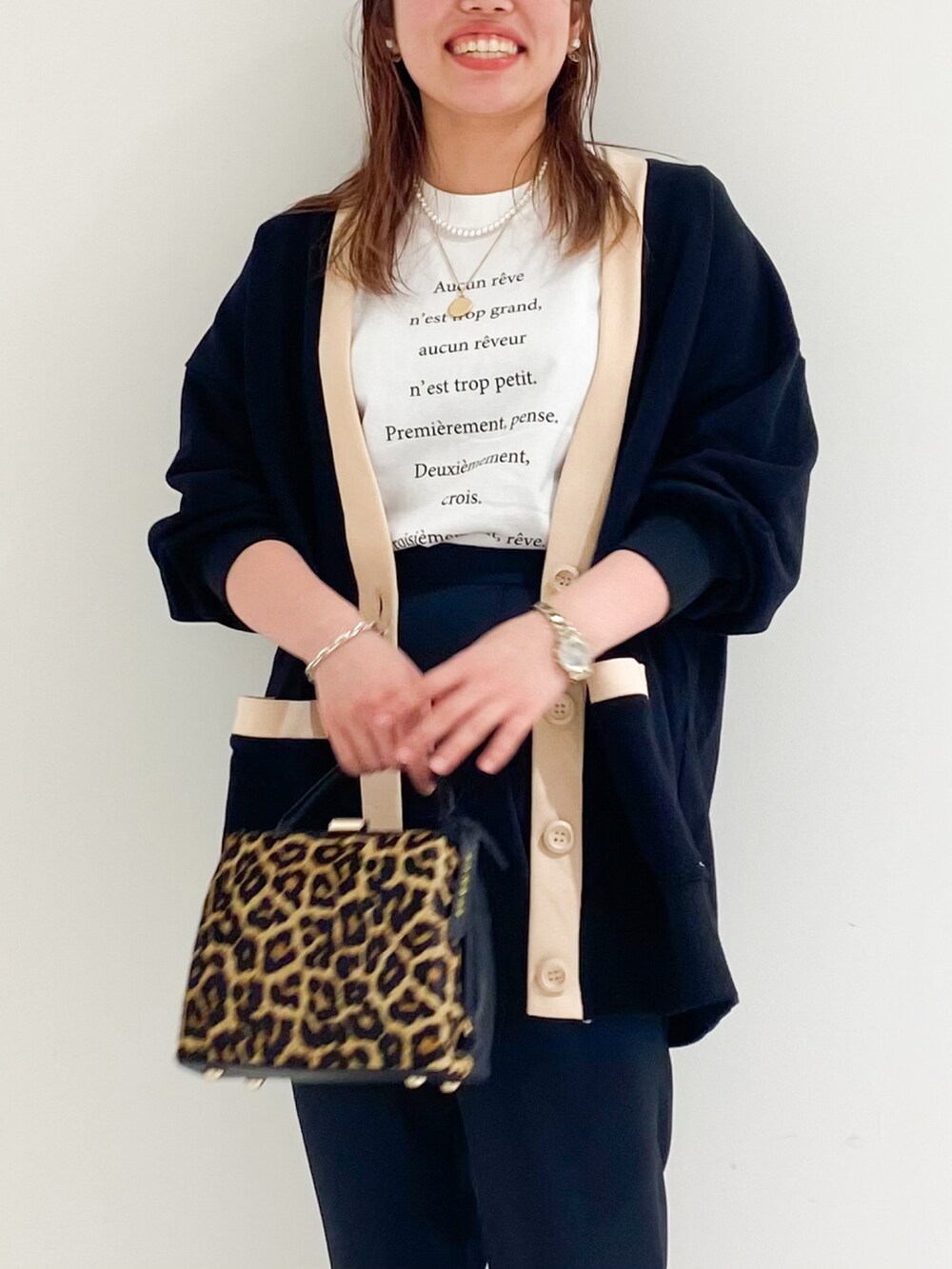 ブラウン系のショルダーバッグ、ブラック系のパンプス、ホワイト系のTシャツ/カットソーを着用したレディースの秋コーディネートの3枚目の写真