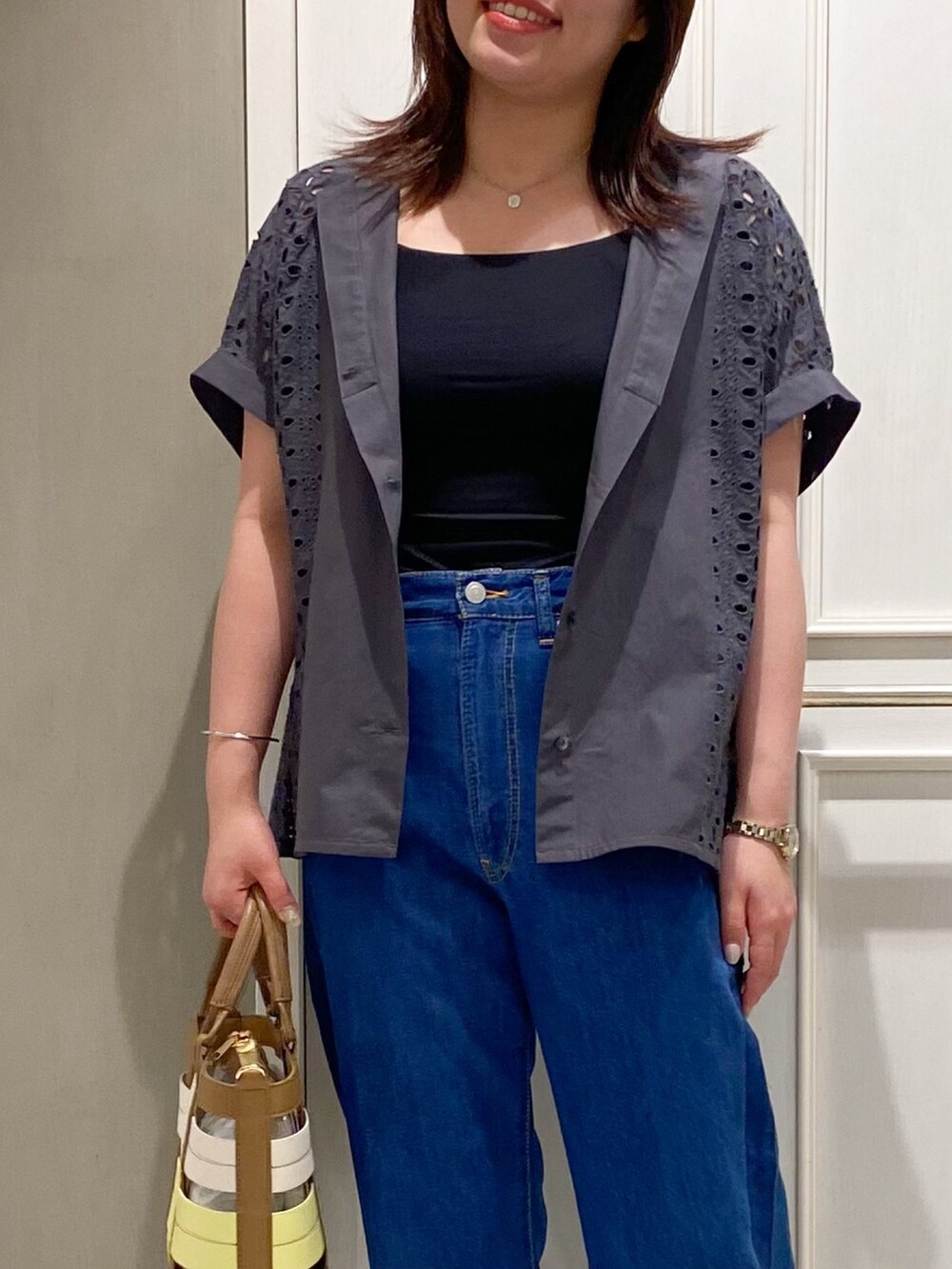 グレー系のシャツ/ブラウス、ブルー系のデニムパンツ、イエロー系のハンドバッグを着用したレディースの夏コーディネートの4枚目の写真