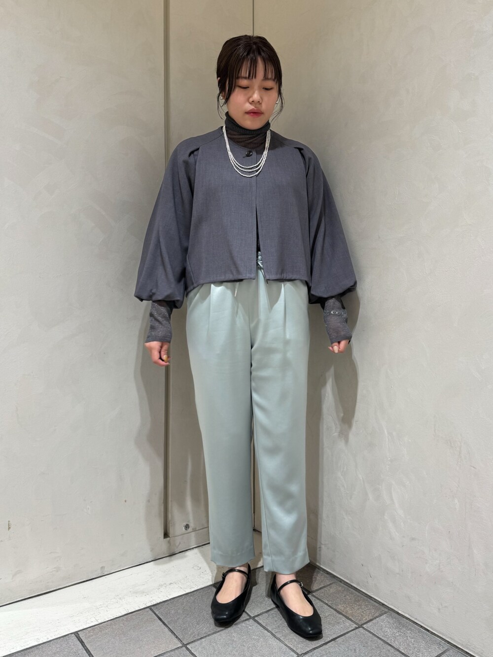 グリーン系のスラックス、グレー系のニット/セーター、グレー系のテーラードジャケットを着用したレディースの秋コーディネートの2枚目の写真