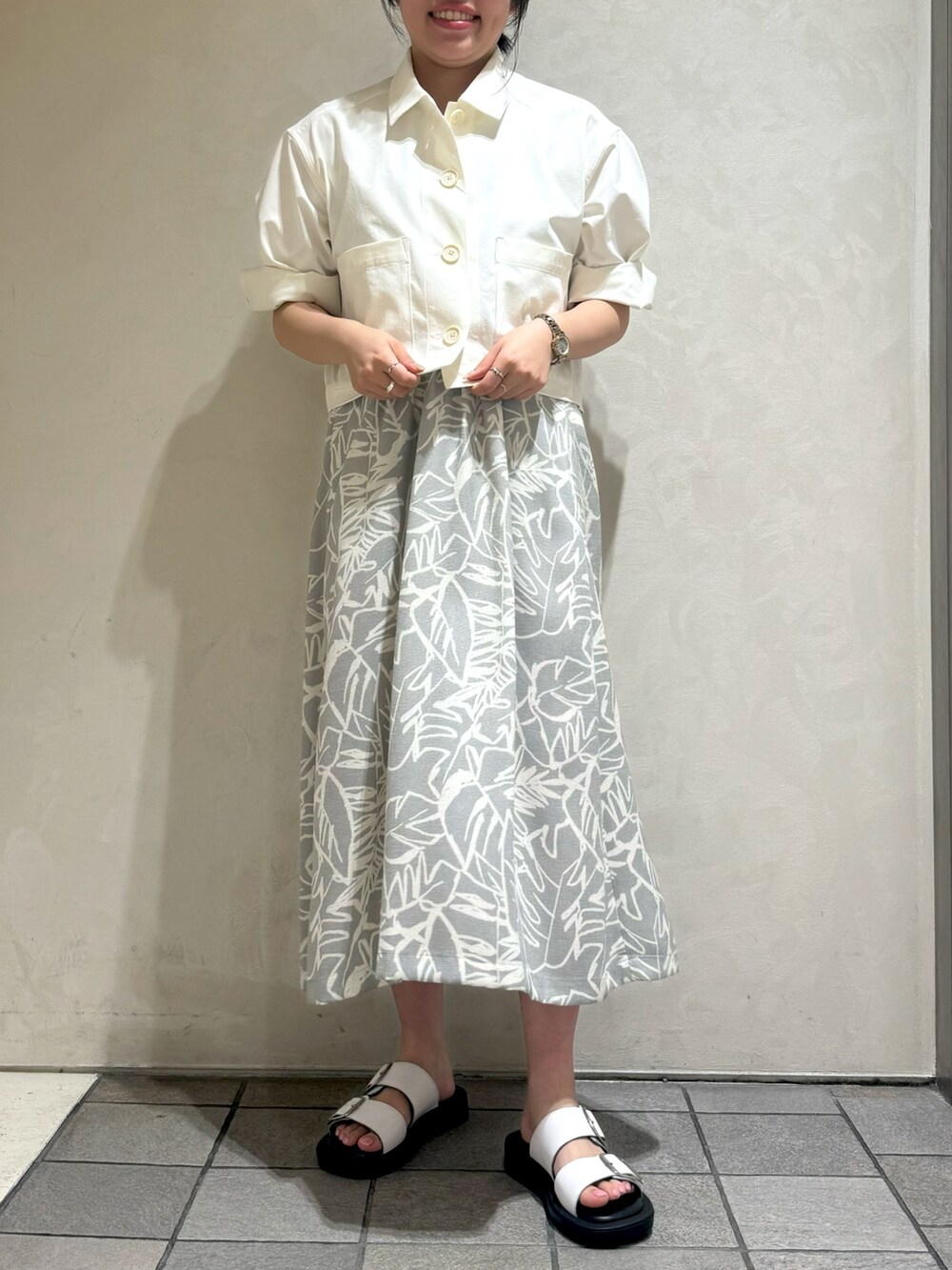 ホワイト系のブルゾン、グレー系のワンピースを着用したレディースの夏コーディネートの2枚目の写真