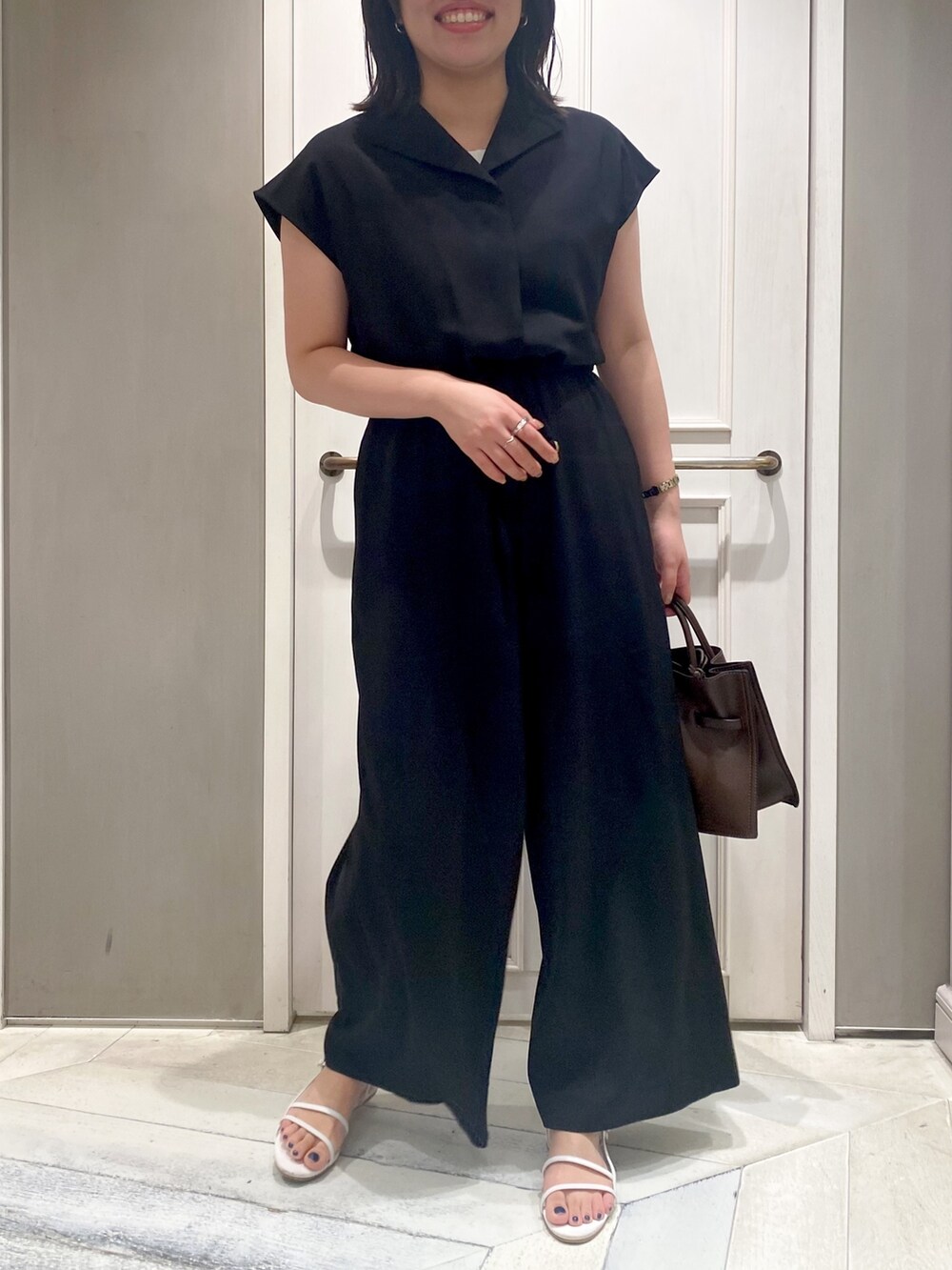 ブラック系のつなぎ/オールインワン、ブラウン系のショルダーバッグ、ホワイト系のサンダルを着用したレディースの夏コーディネートの4枚目の写真