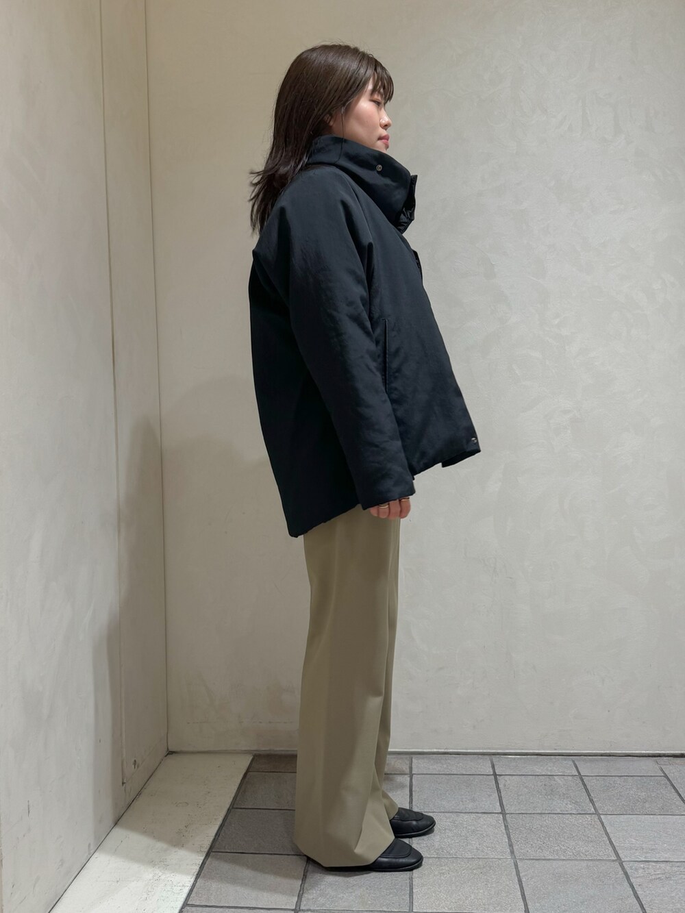 ブラック系のダウンジャケット/コート、グリーン系のスラックスを着用したレディースの秋コーディネートの7枚目の写真