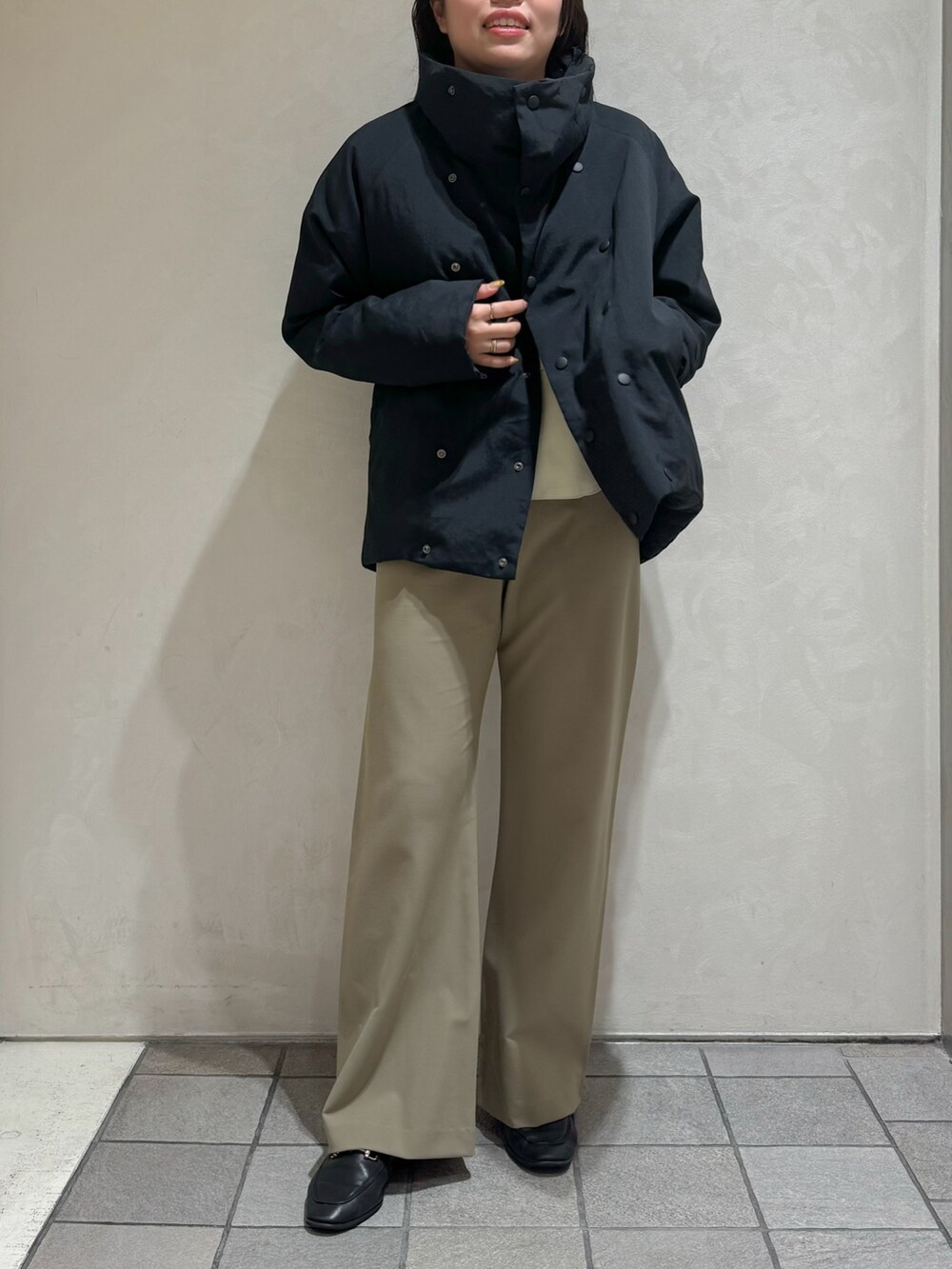 ブラック系のダウンジャケット/コート、グリーン系のスラックスを着用したレディースの秋コーディネートの10枚目の写真