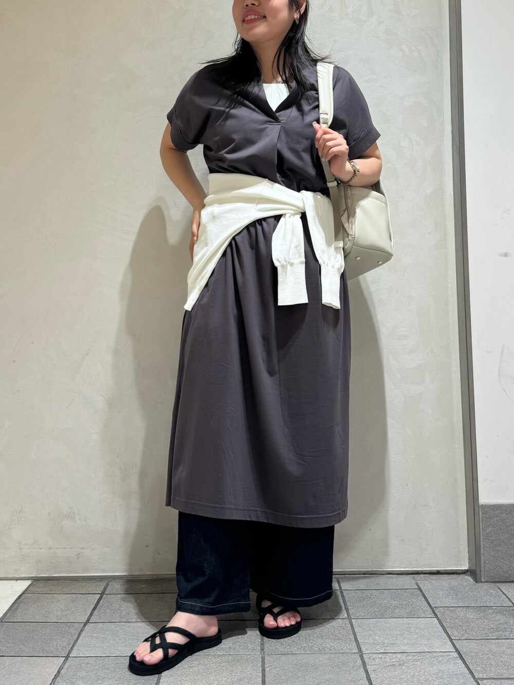 グレー系のワンピース、ブラック系のバックパック/リュック、ホワイト系のカーディガン/ボレロを着用したレディースの夏コーディネートの3枚目の写真