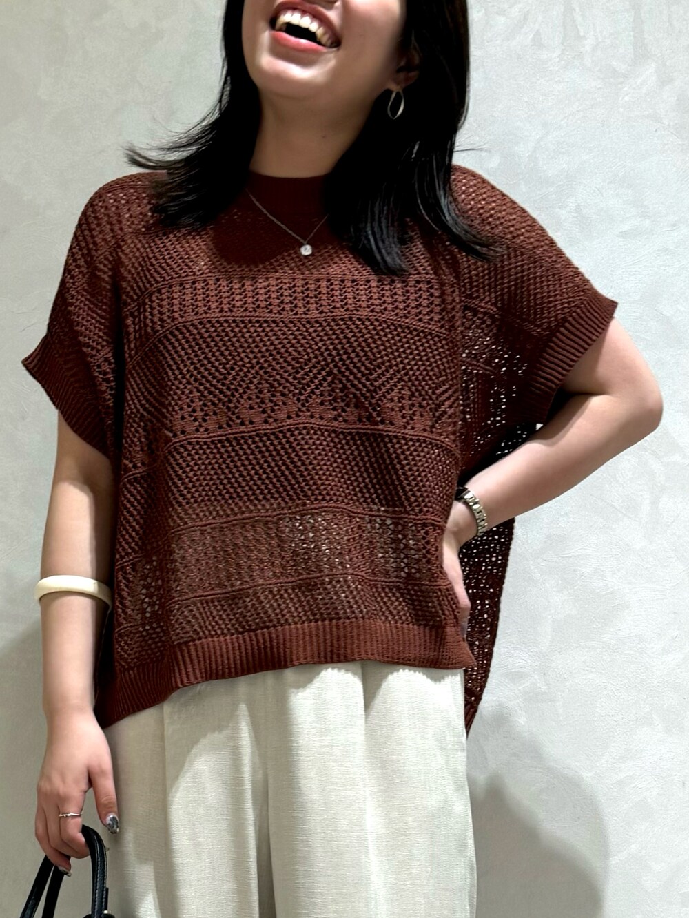 ブラウン系のニット/セーター、ホワイト系のトートバッグを着用したレディースの夏コーディネートの5枚目の写真