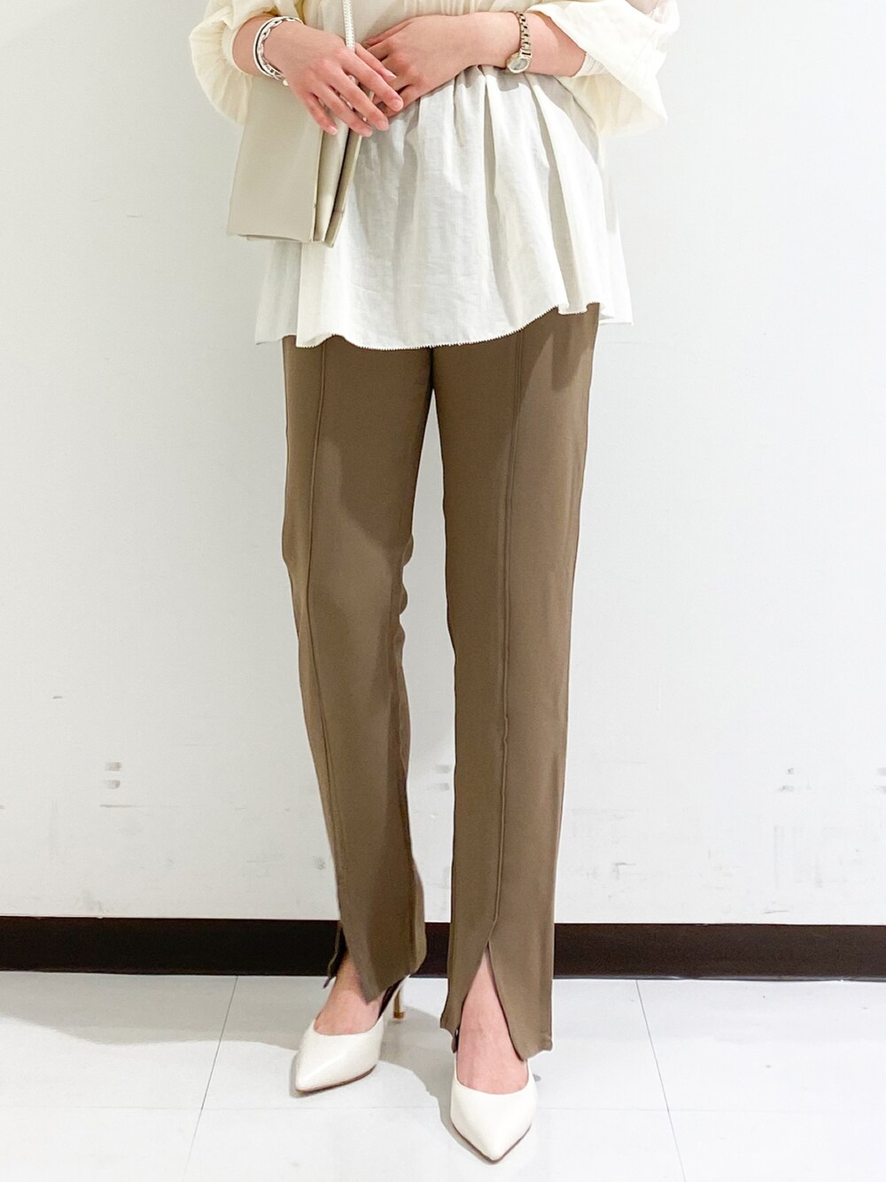 ホワイト系のシャツ/ブラウス、ブラウン系のその他パンツ、ブラック系のパンプスを着用したレディースの秋コーディネートの2枚目の写真