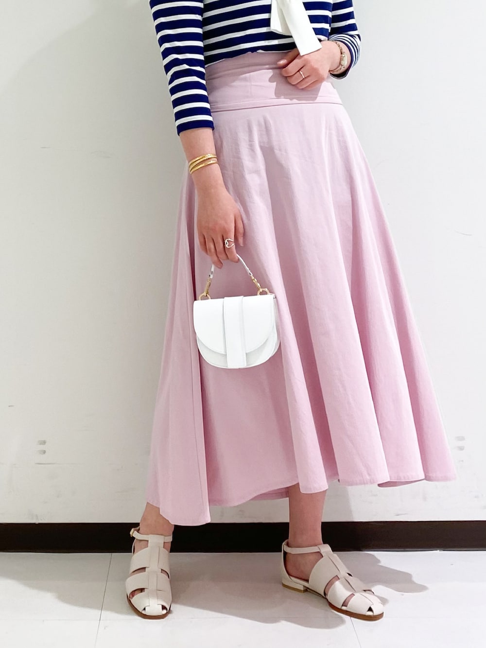 ブルー系のTシャツ/カットソー、ピンク系のスカート、ホワイト系のサンダルを着用したレディースの春コーディネートの3枚目の写真