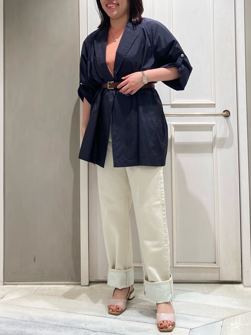 ホワイト系のデニムパンツ、ホワイト系のサンダル、ブルー系のテーラードジャケットを着用したレディースの夏コーディネートの2枚目の写真