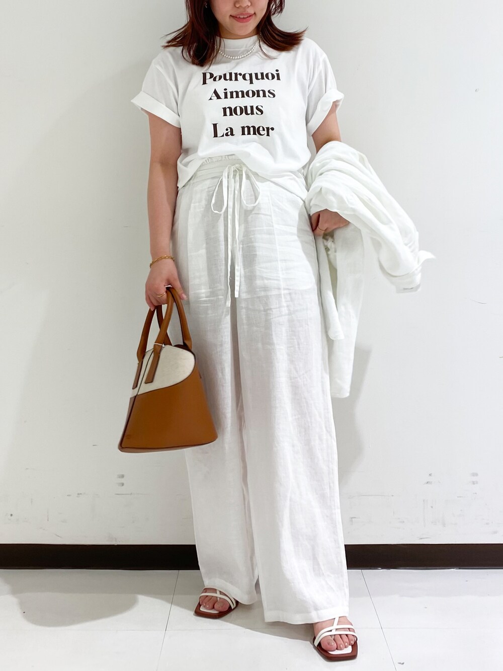 ブラウン系のTシャツ/カットソー、イエロー系のショルダーバッグ、ホワイト系のその他パンツを着用したレディースの夏コーディネートの4枚目の写真