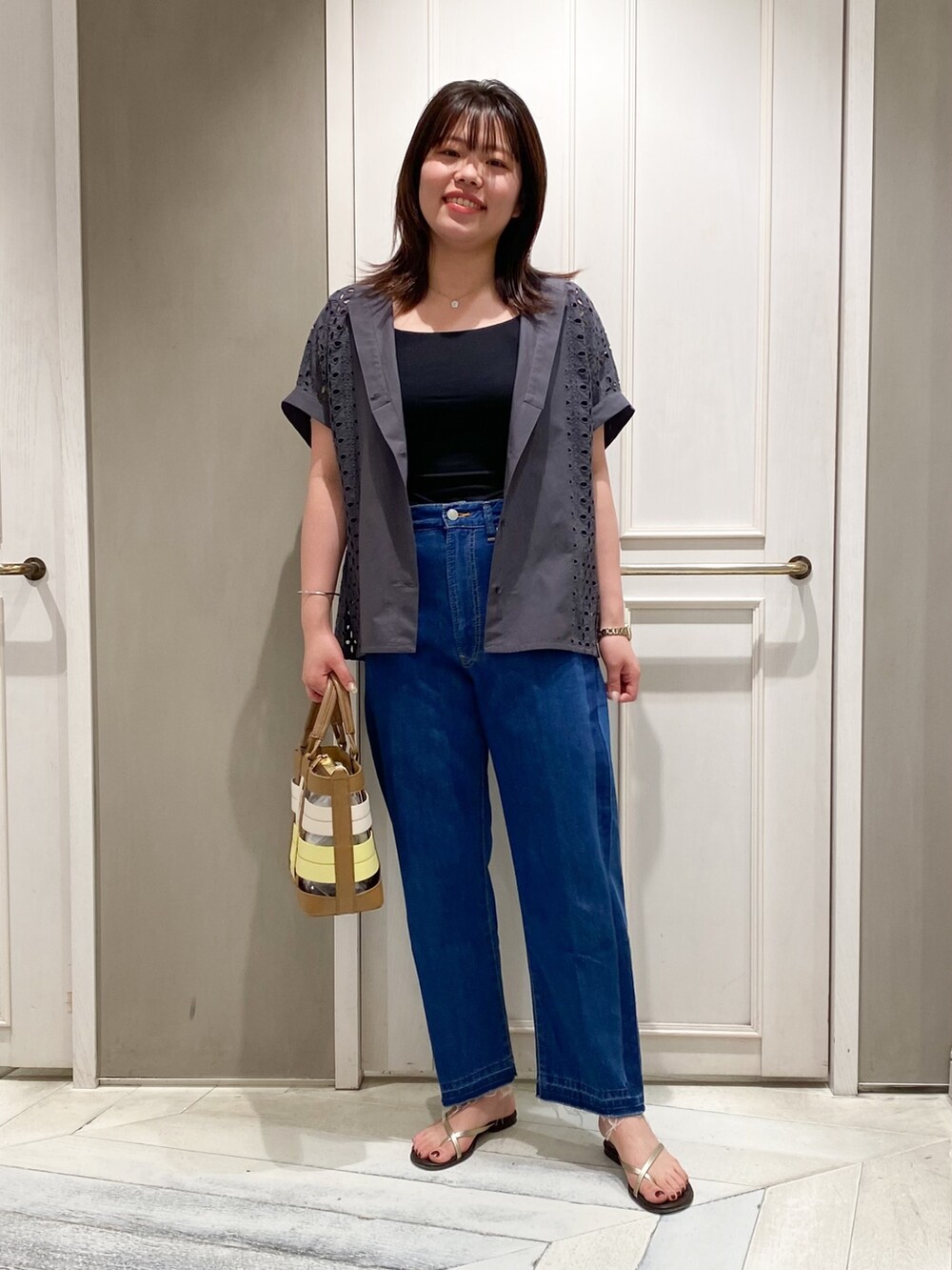 グレー系のシャツ/ブラウス、ブルー系のデニムパンツ、イエロー系のハンドバッグを着用したレディースの夏コーディネートの3枚目の写真