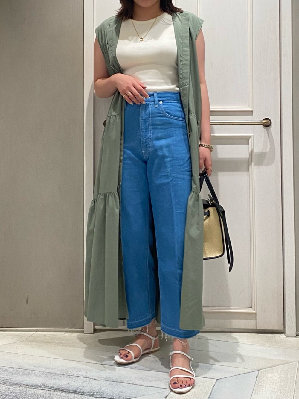 グリーン系のワンピース、ブラック系のトートバッグ、レッド系のサンダルを着用したレディースの夏コーディネートの3枚目の写真