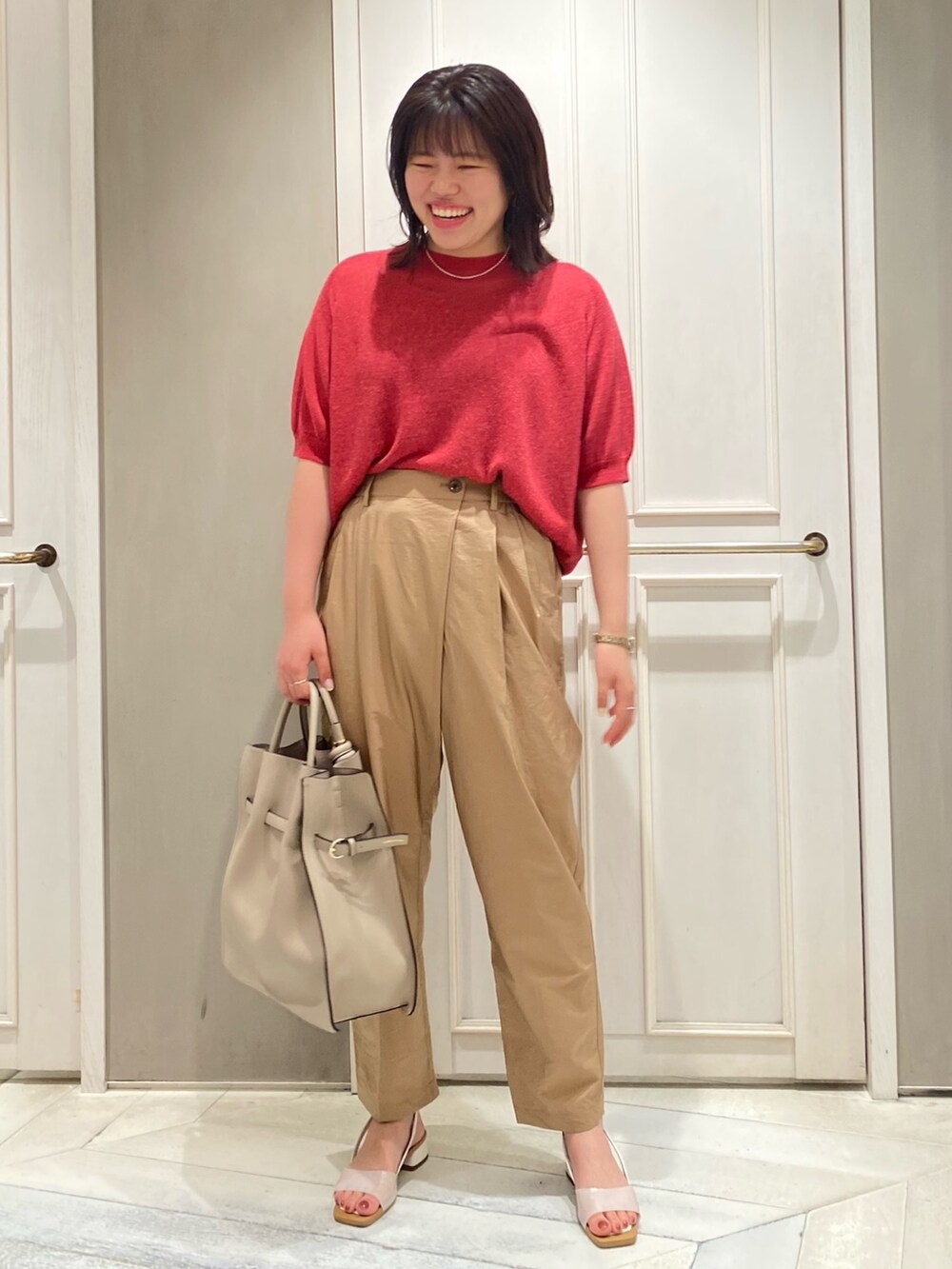 ピンク系のニット/セーター、イエロー系のその他パンツ、ベージュ系のトートバッグを着用したレディースの夏コーディネートの2枚目の写真