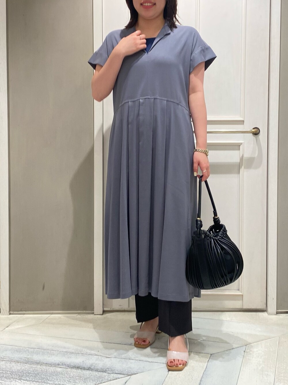 グレー系のワンピース、ホワイト系のサンダル、グレー系のスラックスを着用したレディースの夏コーディネートの3枚目の写真