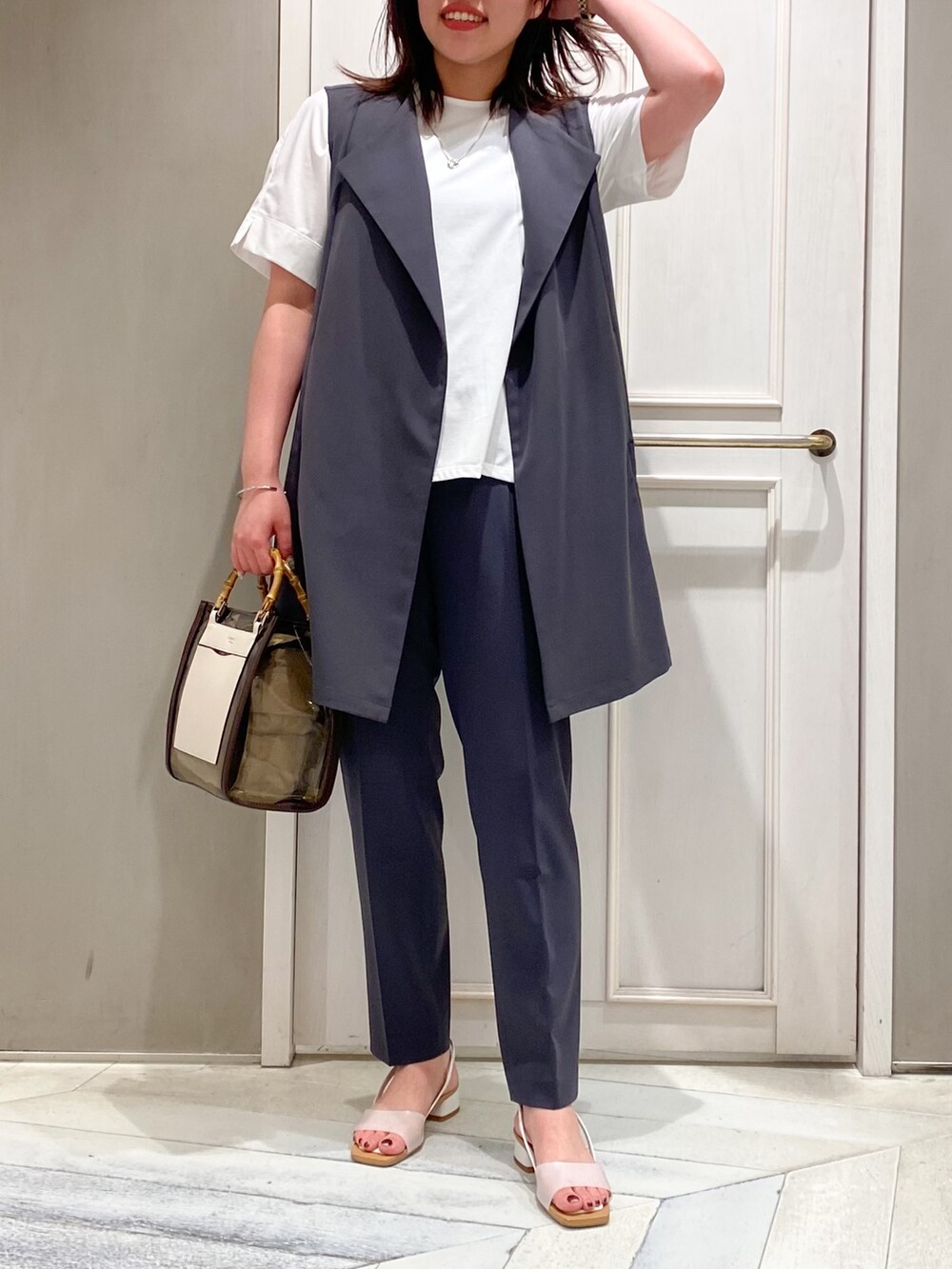 ホワイト系のTシャツ/カットソー、ブラウン系のトートバッグ、ホワイト系のサンダルを着用したレディースの夏コーディネートの2枚目の写真