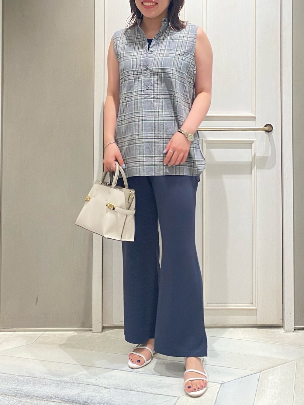 グリーン系のタンクトップ、レッド系のサンダル、ホワイト系のショルダーバッグを着用したレディースの夏コーディネートの4枚目の写真