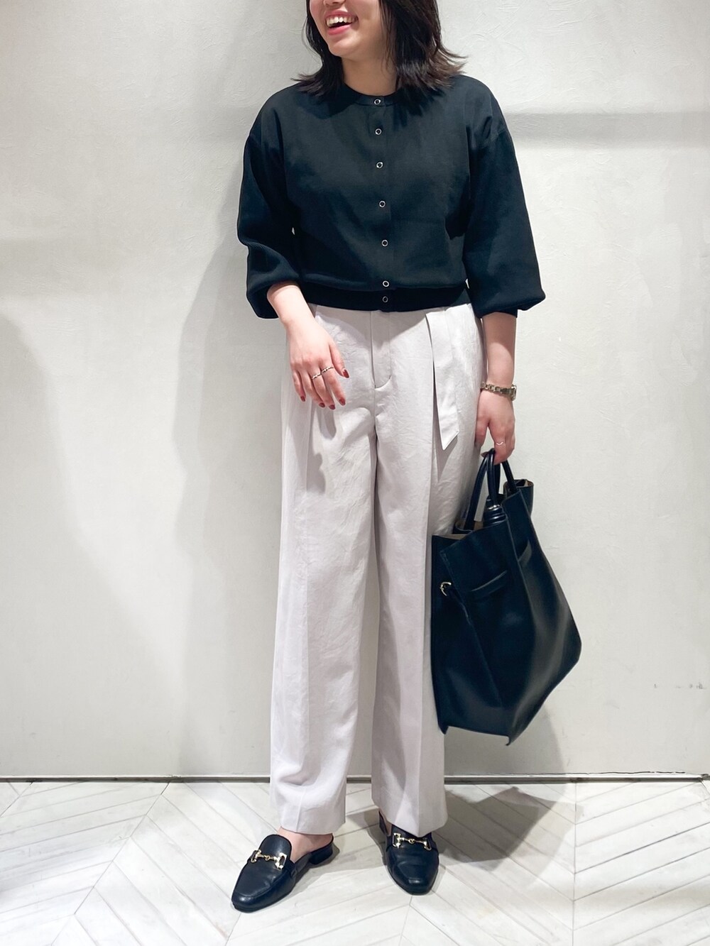 ブラック系のカーディガン/ボレロ、ピンク系のスラックス、ブラック系のトートバッグを着用したレディースの秋コーディネートの5枚目の写真