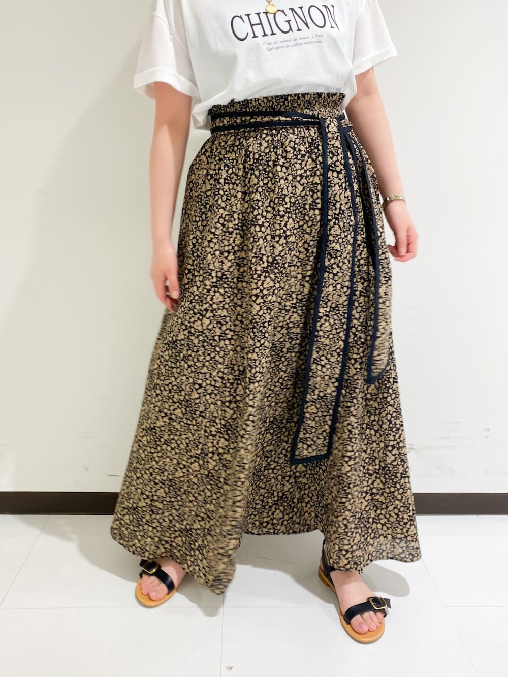 ブラウン系のTシャツ/カットソー、ブラック系のトートバッグ、ブラック系のスカートを着用したレディースの春コーディネートの2枚目の写真