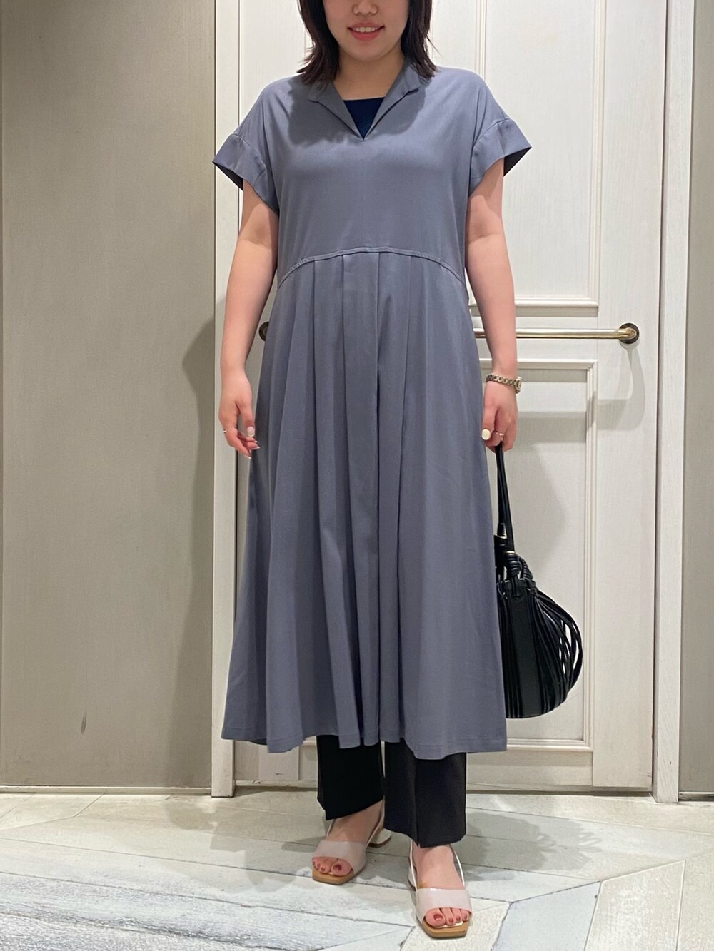 グレー系のワンピース、ホワイト系のサンダル、グレー系のスラックスを着用したレディースの夏コーディネートの4枚目の写真