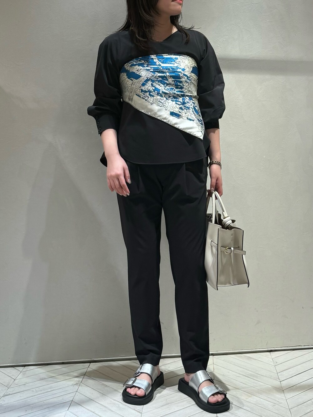 ブラック系のシャツ/ブラウス、ブラック系のスラックスを着用したレディースの春コーディネートの2枚目の写真