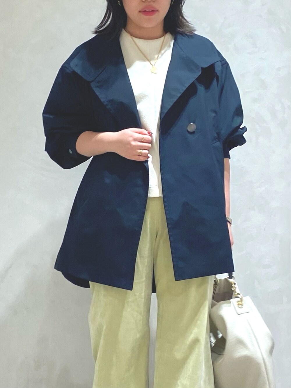 ホワイト系のTシャツ/カットソー、ブルー系のトレンチコート、グリーン系のその他パンツを着用したレディースの秋コーディネートの5枚目の写真