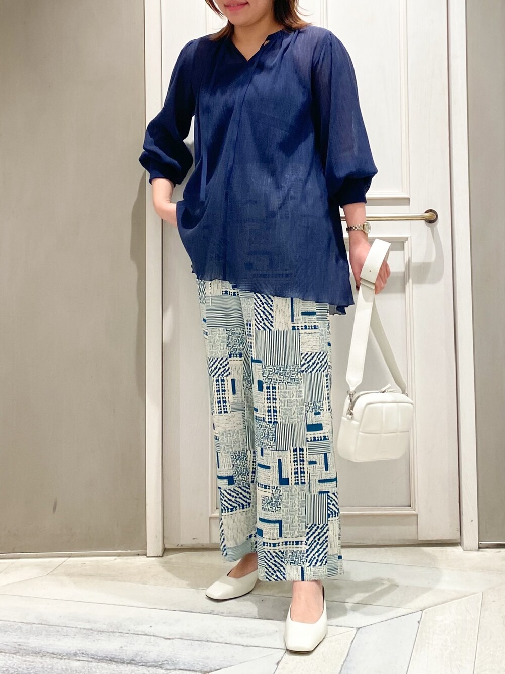 ブルー系のTシャツ/カットソー、グリーン系のその他パンツ、ホワイト系のショルダーバッグを着用したレディースの春コーディネートの3枚目の写真