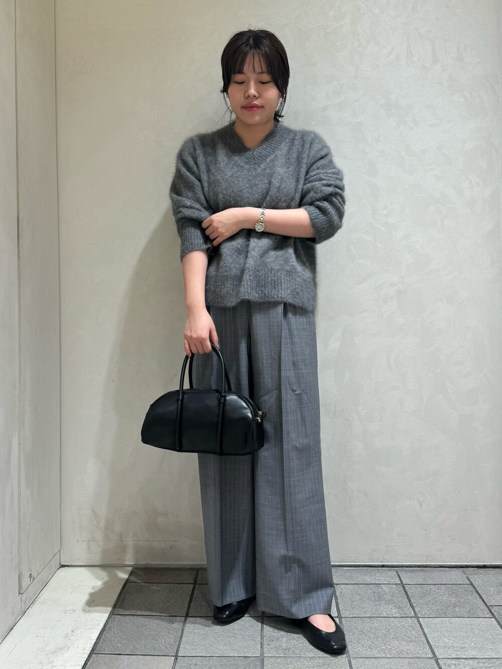 グレー系のニット/セーター、その他のスラックス、ブラック系のボストンバッグを着用したレディースの秋コーディネートの2枚目の写真