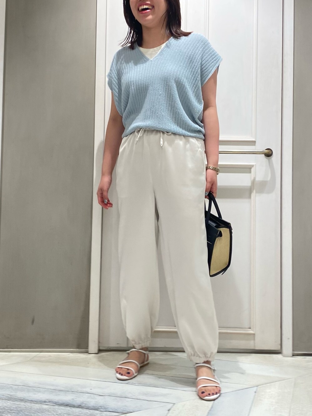 ブルー系のニット/セーター、ホワイト系のその他パンツ、ホワイト系のサンダルを着用したレディースの夏コーディネートの3枚目の写真