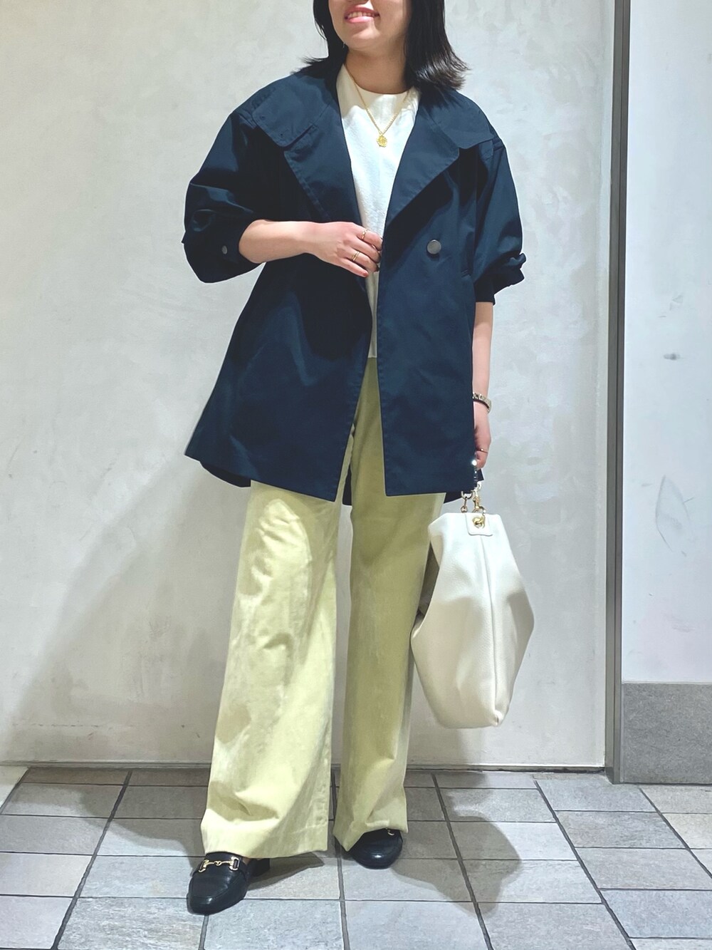 ホワイト系のTシャツ/カットソー、ブルー系のトレンチコート、グリーン系のその他パンツを着用したレディースの秋コーディネートの4枚目の写真