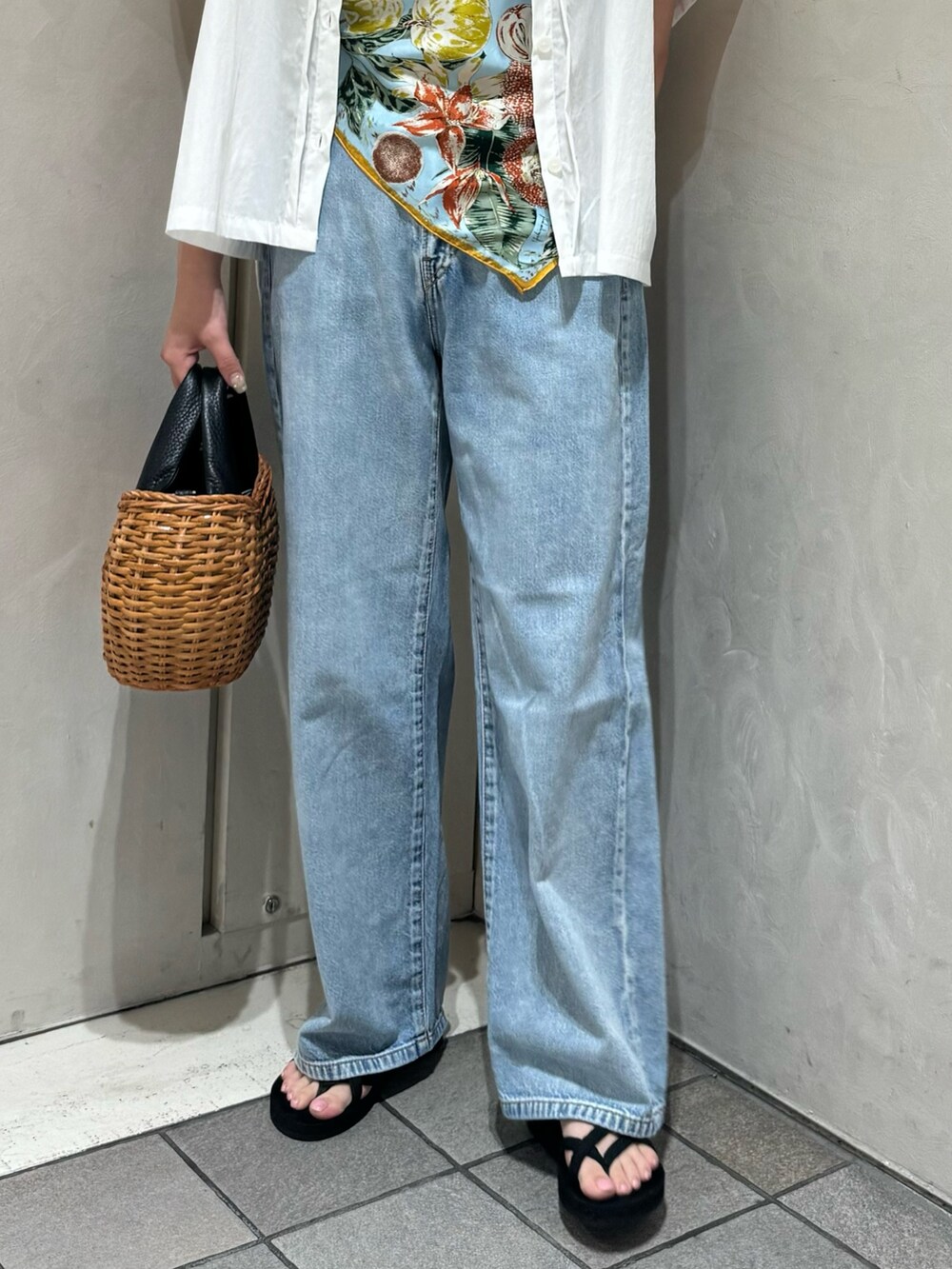 ブラック系のトートバッグ、ブルー系のデニムパンツ、ホワイト系のシャツ/ブラウスを着用したレディースの夏コーディネートの5枚目の写真