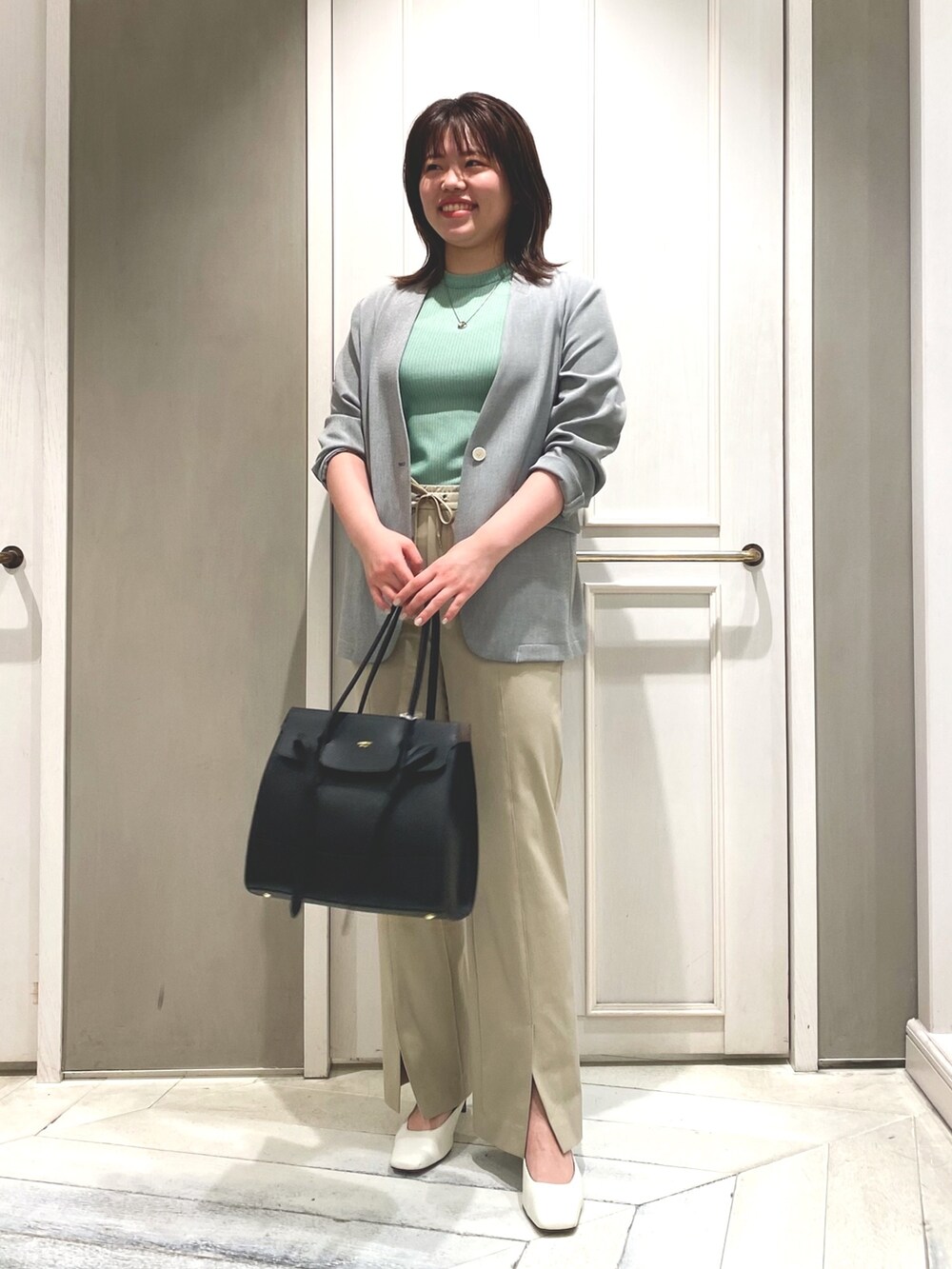 グリーン系のTシャツ/カットソー、ベージュ系のその他パンツ、ブラック系のノーカラージャケットを着用したレディースの春コーディネートの2枚目の写真