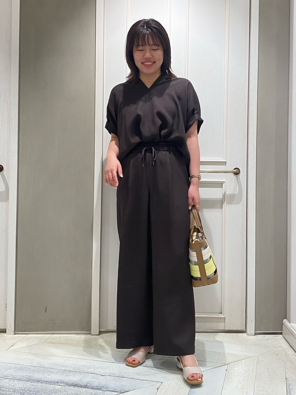 ブラウン系のシャツ/ブラウス、イエロー系のハンドバッグ、ホワイト系のサンダルを着用したレディースの夏コーディネートの5枚目の写真