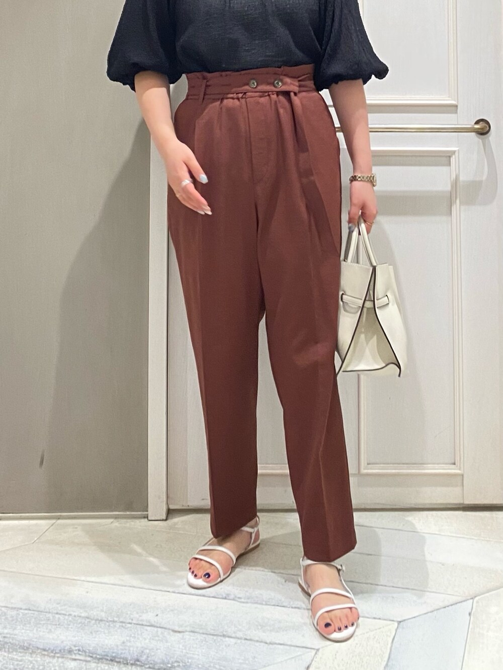 ブラック系のシャツ/ブラウス、レッド系のスラックス、ホワイト系のハンドバッグを着用したレディースの夏コーディネートの3枚目の写真