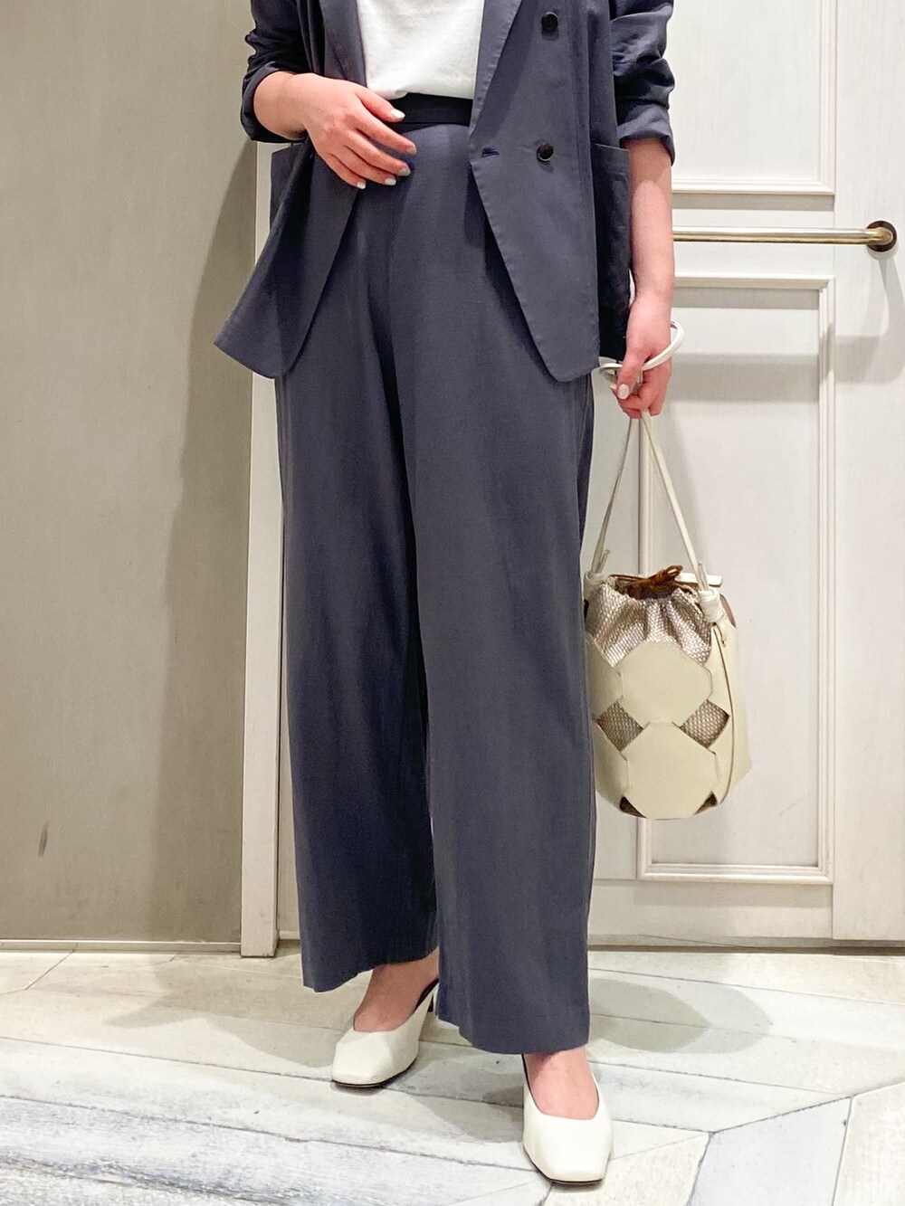 グレー系のその他パンツ、ホワイト系のショルダーバッグ、グレー系のテーラードジャケットを着用したレディースの春コーディネートの2枚目の写真