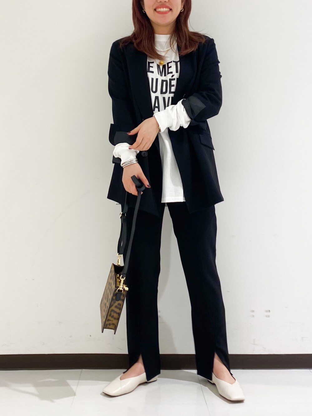 ブラック系のTシャツ/カットソー、ブラウン系のその他パンツ、ホワイト系のパンプスを着用したレディースの秋コーディネートの2枚目の写真