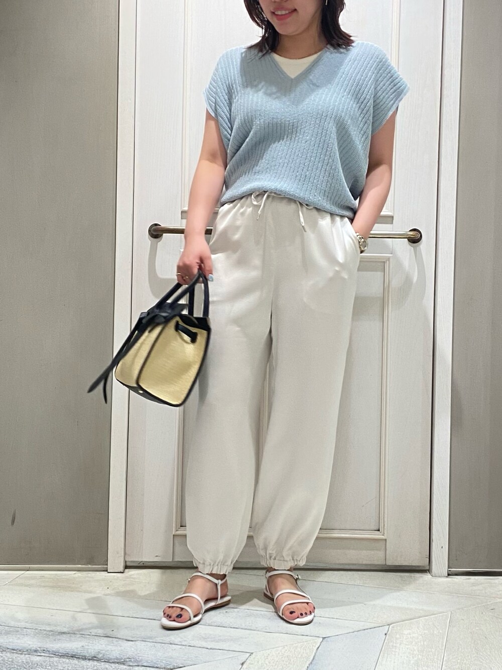 ブルー系のニット/セーター、ホワイト系のその他パンツ、ホワイト系のサンダルを着用したレディースの夏コーディネートの5枚目の写真