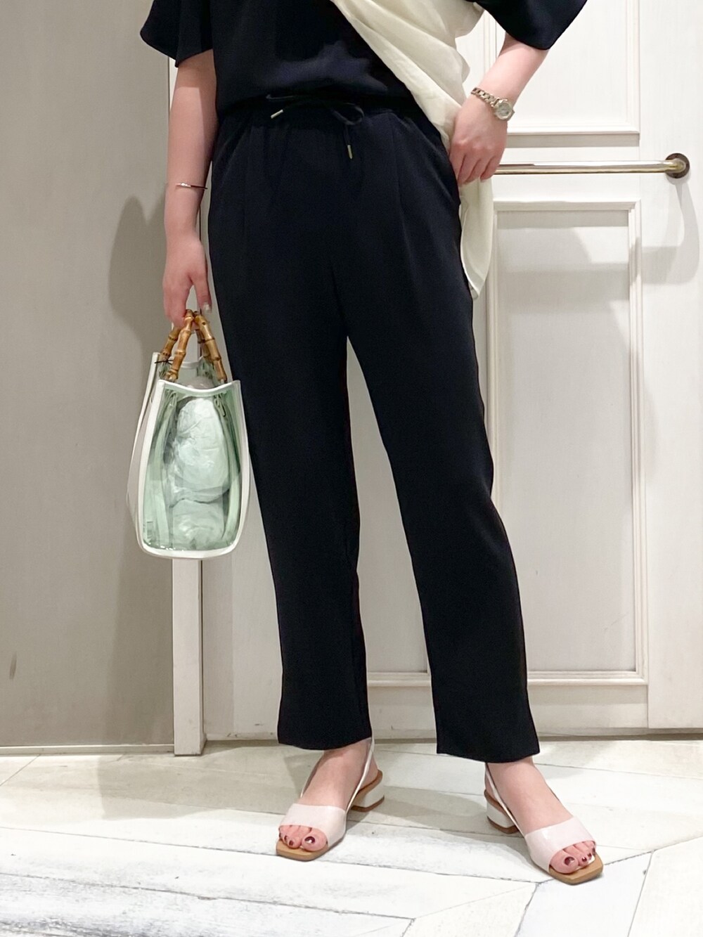 ブラック系のTシャツ/カットソー、ブラック系のスラックス、ホワイト系のトートバッグを着用したレディースの夏コーディネートの5枚目の写真