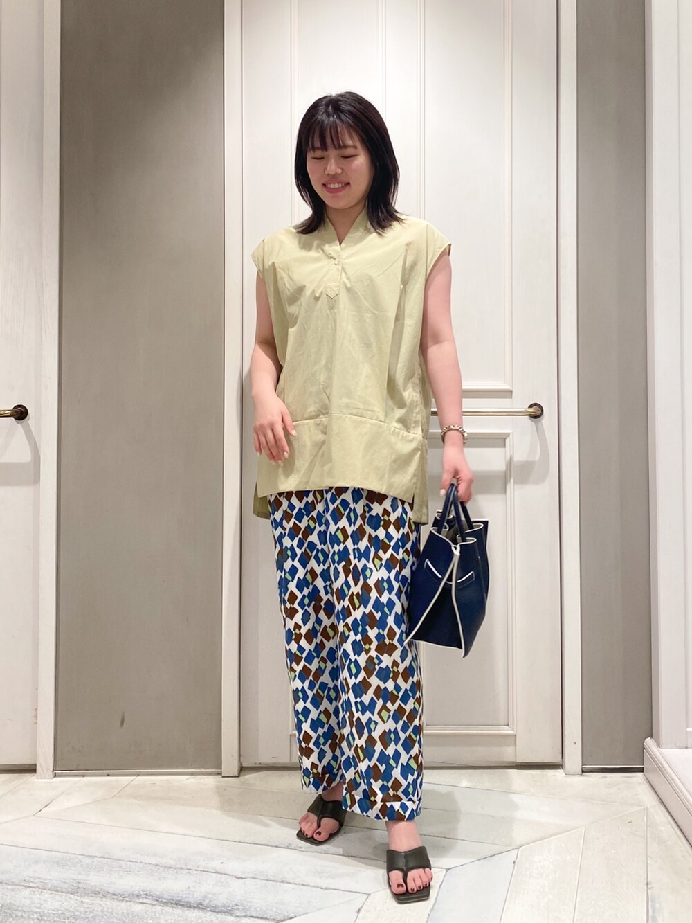 イエロー系のシャツ/ブラウス、その他のその他パンツ、ブルー系のハンドバッグを着用したレディースの春コーディネートの2枚目の写真