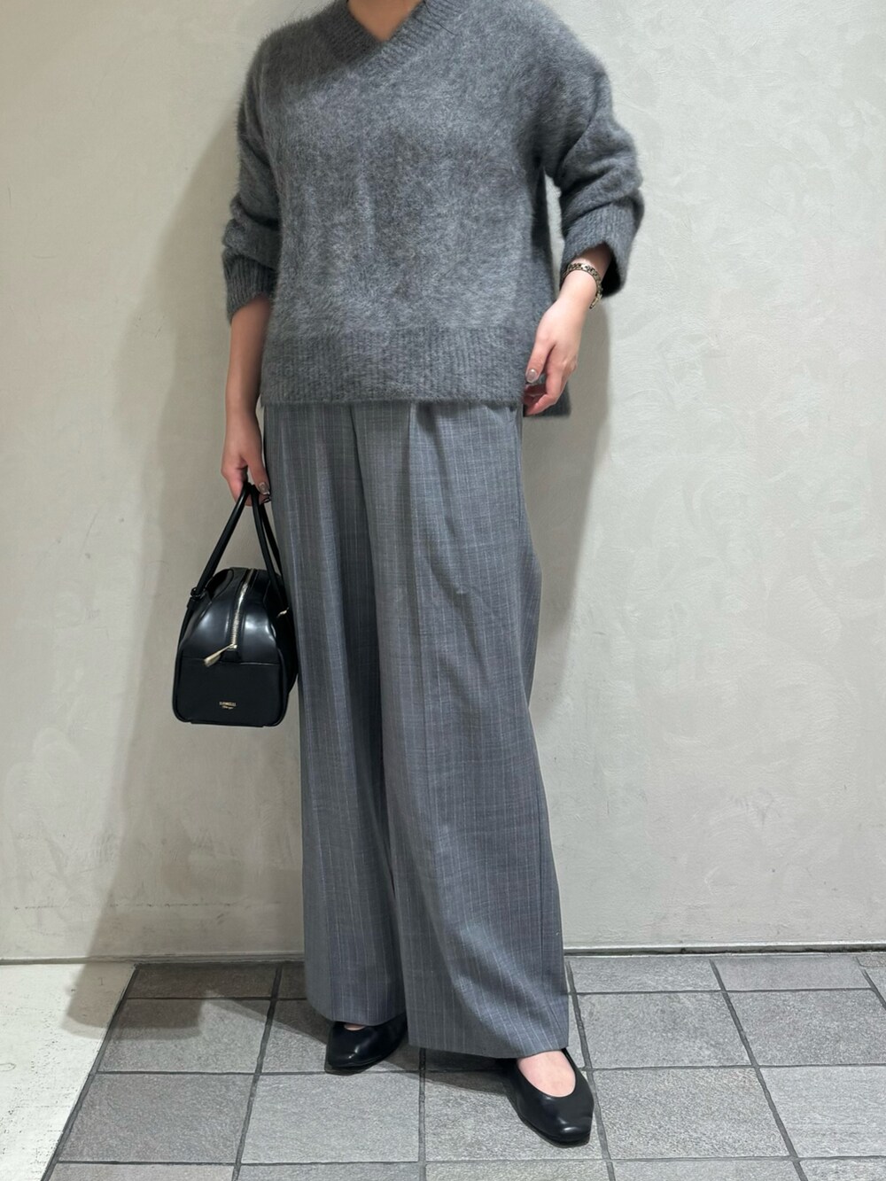 グレー系のニット/セーター、その他のスラックス、ブラック系のボストンバッグを着用したレディースの秋コーディネートの4枚目の写真