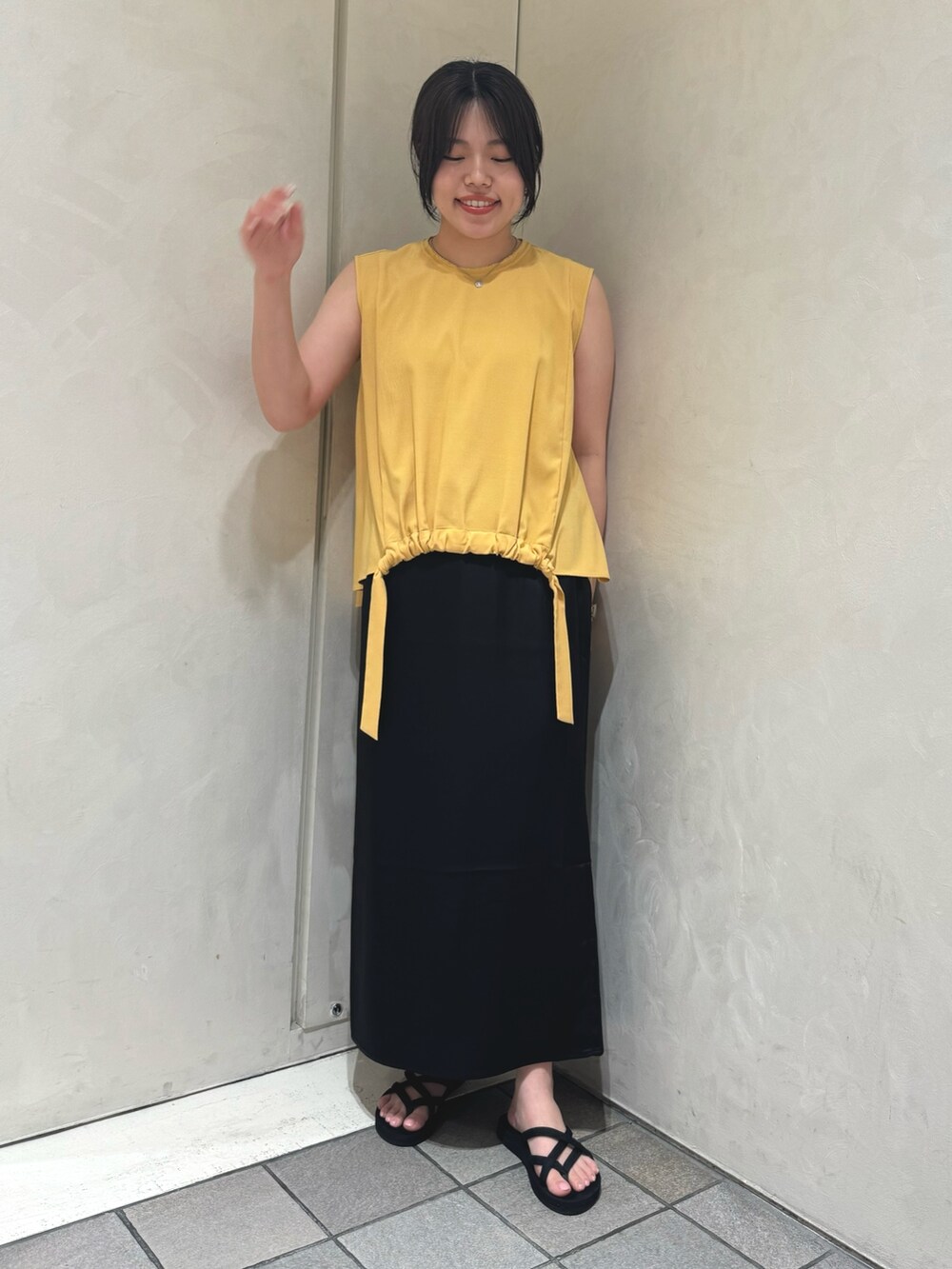 イエロー系のシャツ/ブラウス、ブラック系のスカートを着用したレディースの夏コーディネートの2枚目の写真